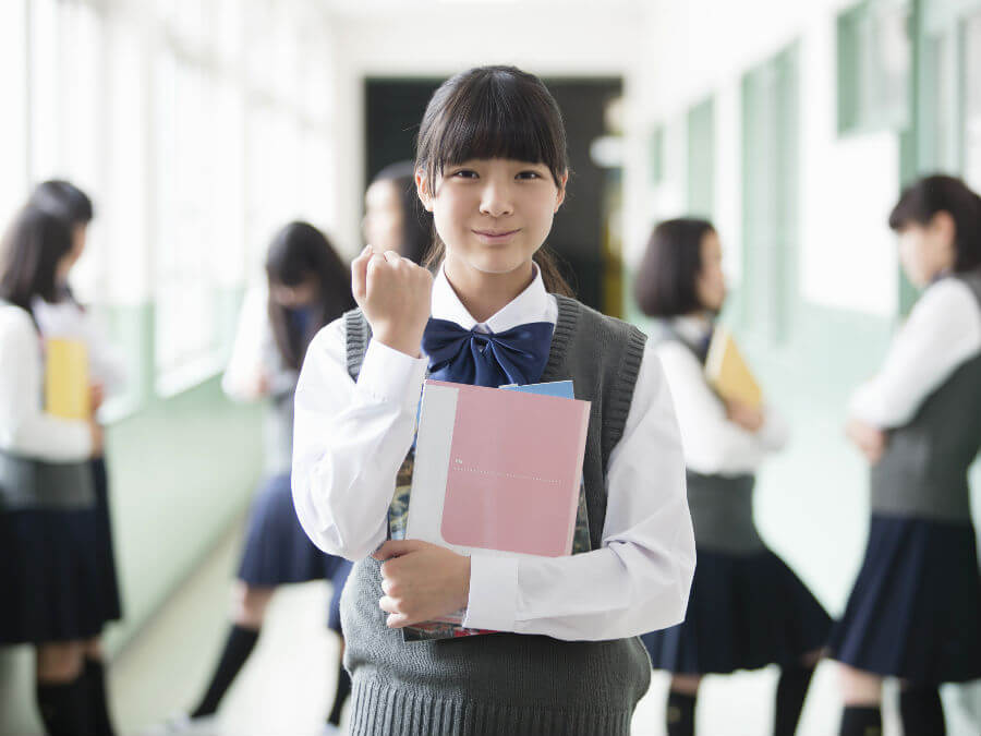 女子高生がこちらを見てガッツポーズをしている様子